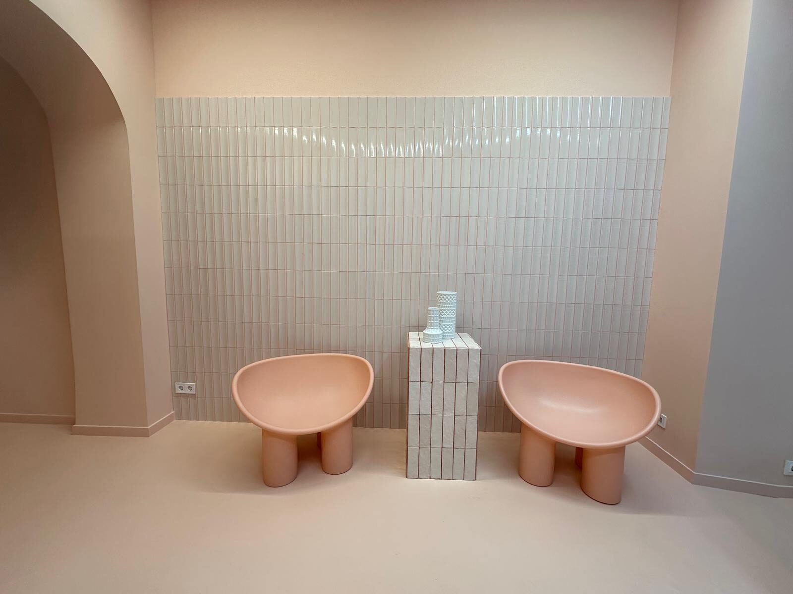 Zona de espera acabada con alicatado blanco y pintura en tono rosado