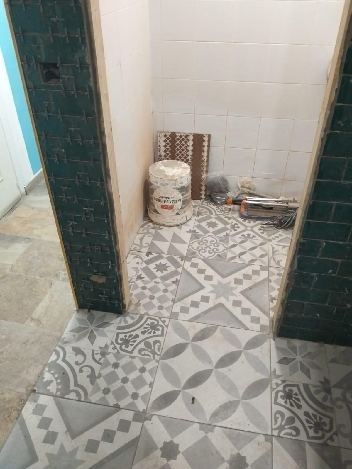 Pavimento hidráulico en grises durante la colocación en los aseos del local