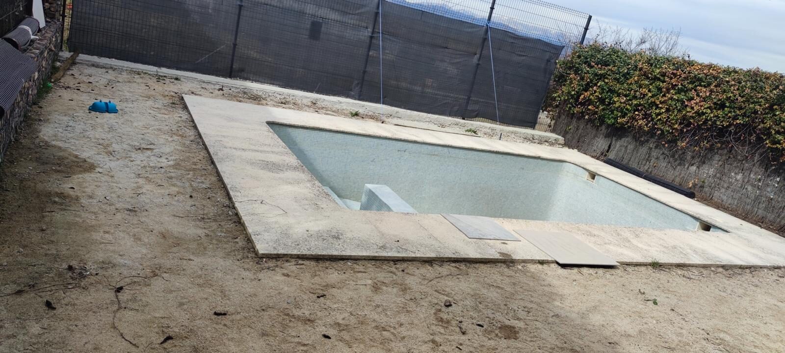 Piscina en proceso de reforma con el vaso reparado y la coronación en ejecución