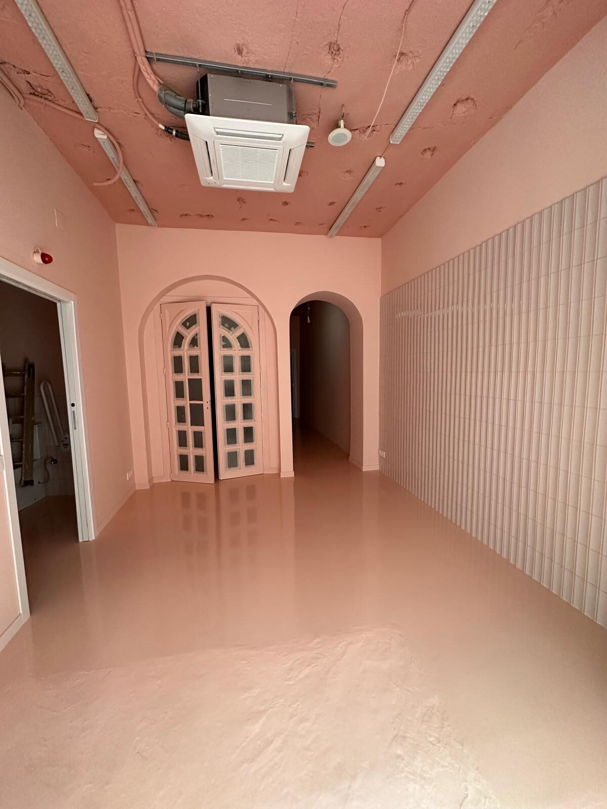 Sala principal terminada con pintura en tono terracota y pavimento continuo