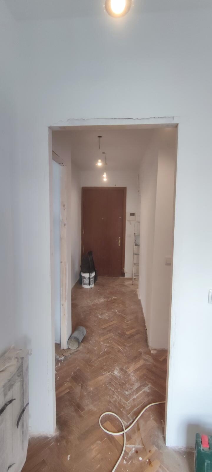 Pasillo de vivienda con suelo de parquet en espiga y carpintería nueva